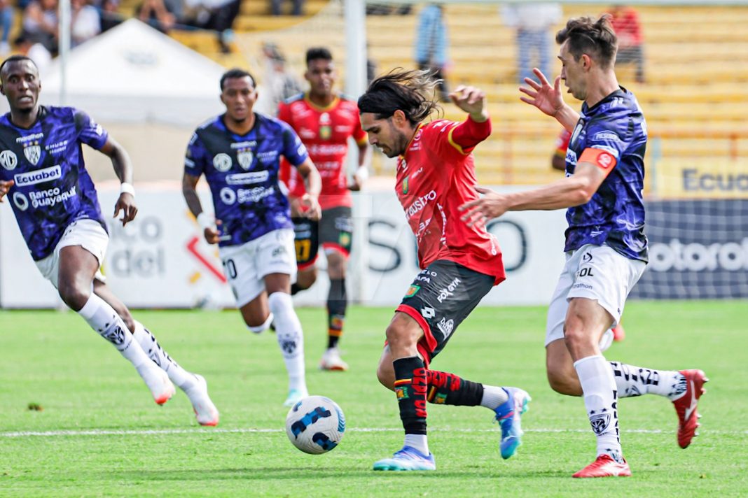 Jugadores de Independiente del Valle intentan abordar a un futbolista del Deportivo Cuenca